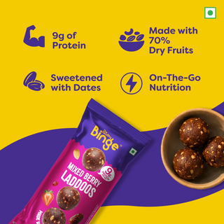A package of THB's Mixed Berry Laddoos is shown on a bright yellow and purple graphic background with marketing text. The package is magenta and purple, and a small bowl of chocolate berry laddoos appears on the right.